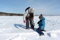 Woman and a little boy sawing a snow block to build an igloo, Novosibirsk, Russia