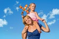 Woman with little girl against summer sky Royalty Free Stock Photo