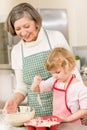 Woman and little girl baking cupcakes together