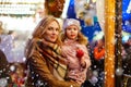 Woman and little girl eating crystalized apple on Christmas mark Royalty Free Stock Photo