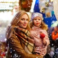 Woman and little girl eating crystalized apple on Christmas mark Royalty Free Stock Photo