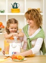 Woman and little girl making fruit juice Royalty Free Stock Photo