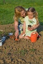 Woman and little girl planting seedlings together