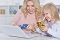 Woman and little girl playing video game on laptop Royalty Free Stock Photo