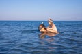 Woman with little girl piggybacking with diving glasses in the water of a beach in Andalusia Royalty Free Stock Photo