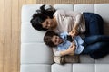 Woman and son lying on sofa with smartphone, above view Royalty Free Stock Photo