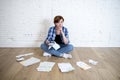 Woman at living room floor with calculator and bank and bills paperwork and documents doing domestic financial accounting