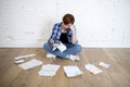 Woman at living room floor with calculator and bank and bills paperwork and documents doing domestic financial accounting
