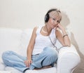 Woman in living room listening to MP3 player smiling Royalty Free Stock Photo