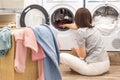 Woman Loading Dirty Clothes In Washing Machine For Washing In modern Utility Room Royalty Free Stock Photo