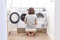 Woman Loading Dirty Clothes In Washing Machine For Washing In modern Utility Room Royalty Free Stock Photo