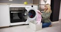 Woman Loading Dirty Clothes In Washing Machine For Washing Royalty Free Stock Photo