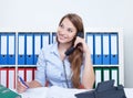 Woman with long blond hair at office speaking with a client at phone Royalty Free Stock Photo