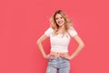 Woman with long blond wavy hair smiles happily while looking at the camera. Fashionable girl posing Royalty Free Stock Photo