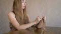 Woman with long blonde hair knitting