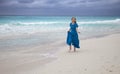 Woman in a long blue dress goes on the sea coast Cayo Largo island, Cuba Royalty Free Stock Photo