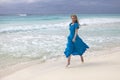 Woman in a long blue dress goes on the sea coast Cayo Largo island, Cuba Royalty Free Stock Photo