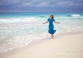 The woman in a long blue dress goes on the sea coast Cayo Largo`s island, Cuba Royalty Free Stock Photo