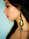 Woman with long blue-golden earring Royalty Free Stock Photo