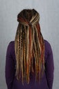 Woman with long dreadlocks shot from behind. Rear view of hairstyle dreadlocks. dreadlocks on the head of a young girl. Girl with