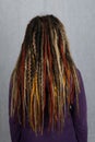 Woman with long dreadlocks shot from behind. Rear view of hairstyle dreadlocks. dreadlocks on the head of a young girl. Girl with