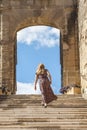 Woman in a long dress is climbing the steps of the abbey of Saint Antoine