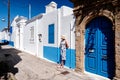 Woman in long dress posing at alley in greek village Koskinou in Rhodes island in Greece