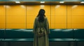 a woman in a long dress stands alone in an empty subway station