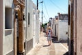 Woman in long dress walking through an alley in greek village Koskinou in Rhodes island in Greece
