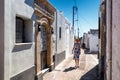 Woman in long dress walking through an alley in greek village Koskinou in Rhodes island in Greece