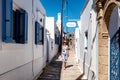 Woman in long dress walking through an alley in greek village Koskinou in Rhodes island in Greece