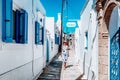 Woman in long dress walking through an alley in greek village Koskinou in Rhodes island in Greece