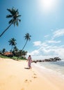 Woman in long dress walks on tropical island beach at sunny afternoon Royalty Free Stock Photo