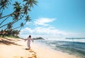 Woman in long dress walks on tropical island beach Royalty Free Stock Photo