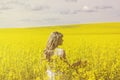 Woman with long hair back view, yellow rapeseed canola field enjoying nature and sunlight. Royalty Free Stock Photo