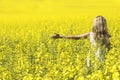 Woman with long hair back view, yellow rapeseed canola field enjoying nature and sunlight. Royalty Free Stock Photo