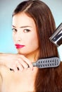 Woman with long hair holding blow dryer and comb Royalty Free Stock Photo