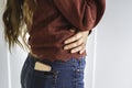 Woman with long hair with mobile phone in the back pocket of her jeans. White background Royalty Free Stock Photo