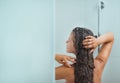 Woman with long hair taking shower. Rear view