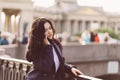 Woman with long hair talking on phone. Autumn or winter, girl in outdoor. Beautiful intelligent brunette in street of St. Royalty Free Stock Photo