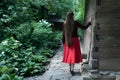 Woman with long hair in the village. Girl walks in the park. Back view