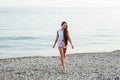 Tanned woman with long hair walks on beach by the sea Royalty Free Stock Photo