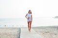 Tanned woman with long hair walks on beach by the sea Royalty Free Stock Photo