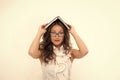 Woman with long hair white blouse hold book as roof. Teacher with glasses looks attractive. Seductive office