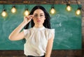 Woman with long hair in white blouse stands in classroom. Strict teacher concept. Lady strict teacher on calm face Royalty Free Stock Photo