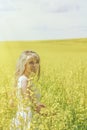 Woman with long hair, yellow rapeseed canola field enjoying nature and sunlight. Royalty Free Stock Photo