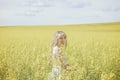 Woman with long hair, yellow rapeseed canola field enjoying nature and sunlight. Royalty Free Stock Photo