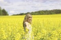 Woman with long hair, yellow rapeseed canola field enjoying nature and sunlight. Royalty Free Stock Photo