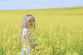 Woman with long hair, yellow rapeseed canola field enjoying nature and sunlight. Royalty Free Stock Photo