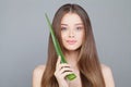 Woman with Long Healthy Hair Holding Green Aloe Leaf